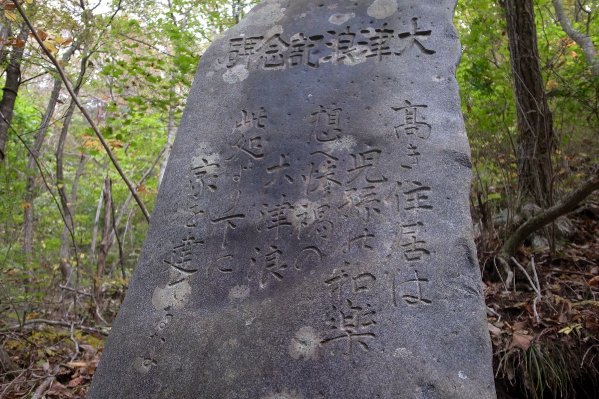 2011年に撮影された、宮古市姉吉の大津浪記念碑。秋の林の中に立つ風化した石に、碑文が刻まれている